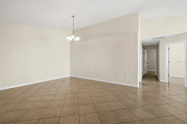 an empty room and chandelier fan