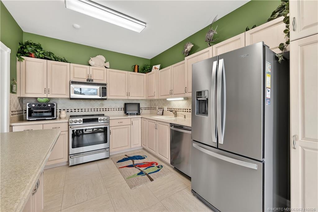 12392 Harbour Ridge Boulevard, Unit 54 Palm City, FL 34990 - Photo 12 of 35 a kitchen with a refrigerator and white cabinets