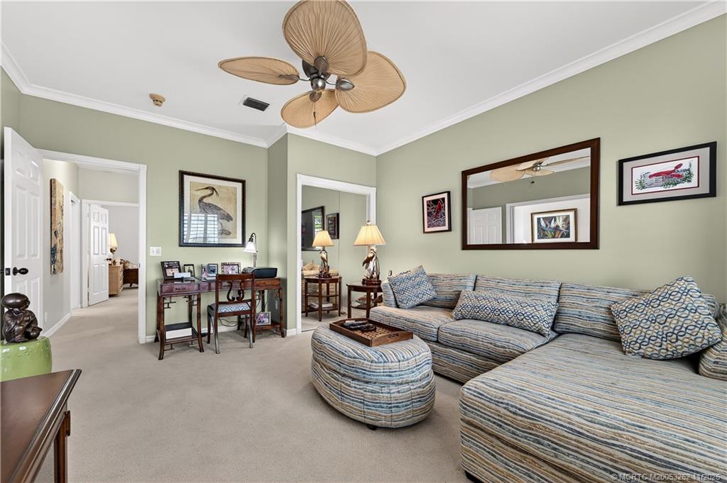 12392 Harbour Ridge Boulevard, Unit 54 Palm City, FL 34990 - Photo 22 of 35 a living room with furniture and a chandelier
