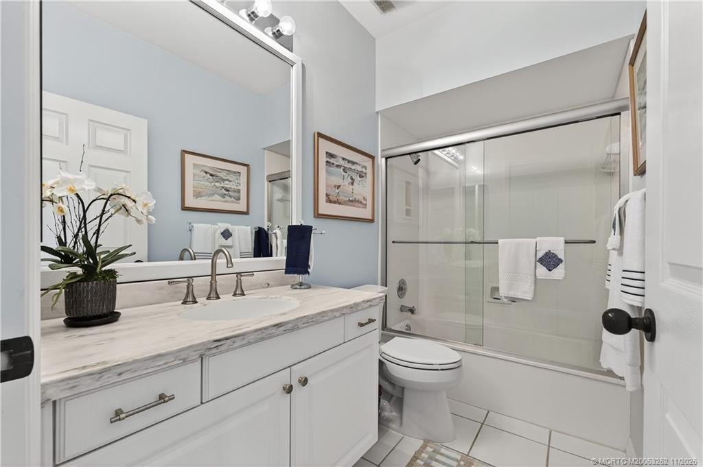 12392 Harbour Ridge Boulevard, Unit 54 Palm City, FL 34990 - Photo 23 of 35 a bathroom with a double vanity sink toilet and shower