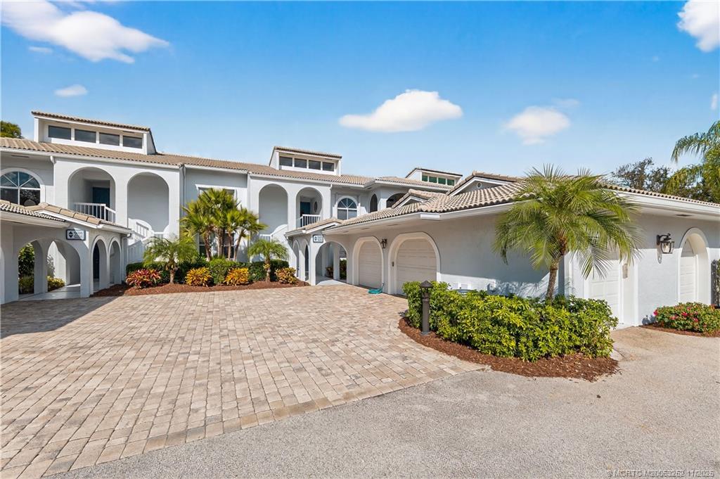 12392 Harbour Ridge Boulevard, Unit 54 Palm City, FL 34990 - Photo 3 of 35 a front view of a house with a yard and outdoor seating