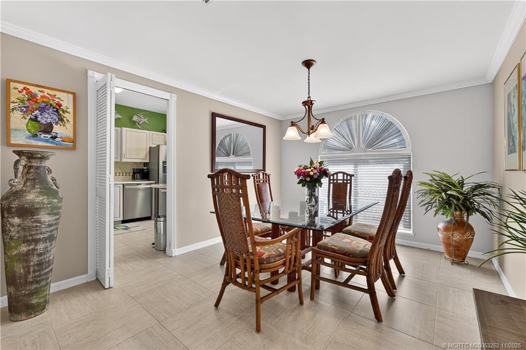 12392 Harbour Ridge Boulevard, Unit 54 Palm City, FL 34990 - Photo 9 of 35 a dining room with furniture potted plants and wooden floor