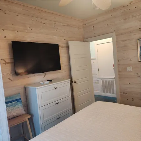 a bedroom with a bed and flat screen tv