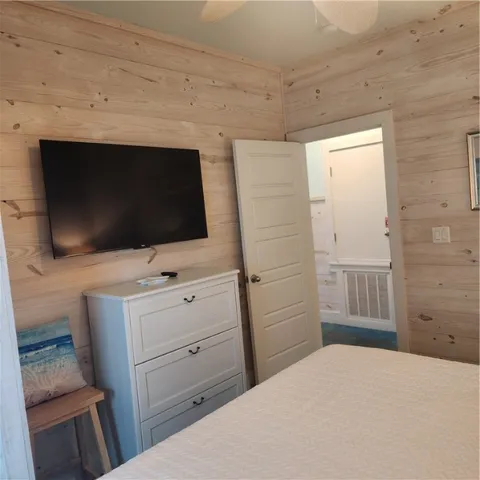 a spacious bedroom with a bed and a television