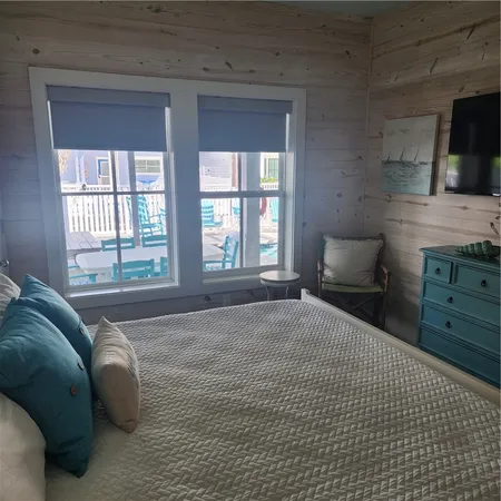 a spacious bedroom with a bed and a television
