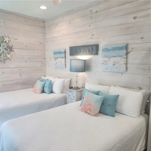 a bedroom with a bed and a table with wooden floor