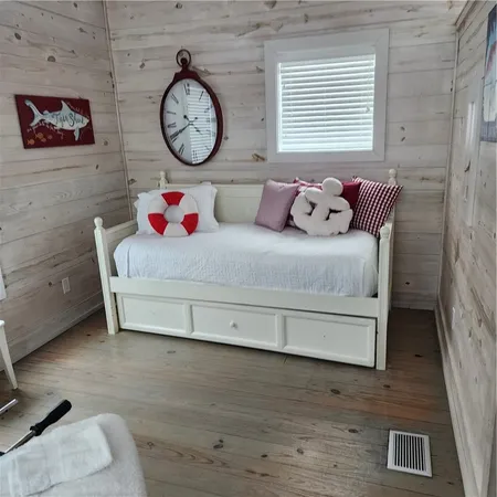 a bedroom with a bed and a table with wooden floor