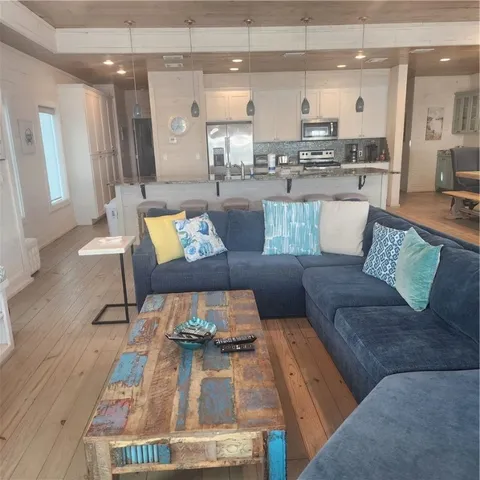 a living room with furniture and a dining table with wooden floor