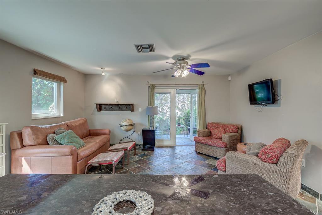 9144 7th Street North Naples, FL 34108 - Photo 12 of 20 a living room with furniture a large window and a flat screen tv