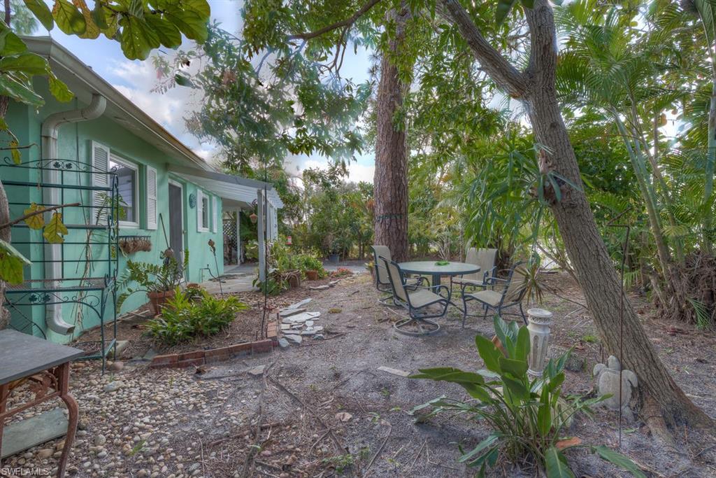 9144 7th Street North Naples, FL 34108 - Photo 14 of 20 a view of a chairs and table in the backyard