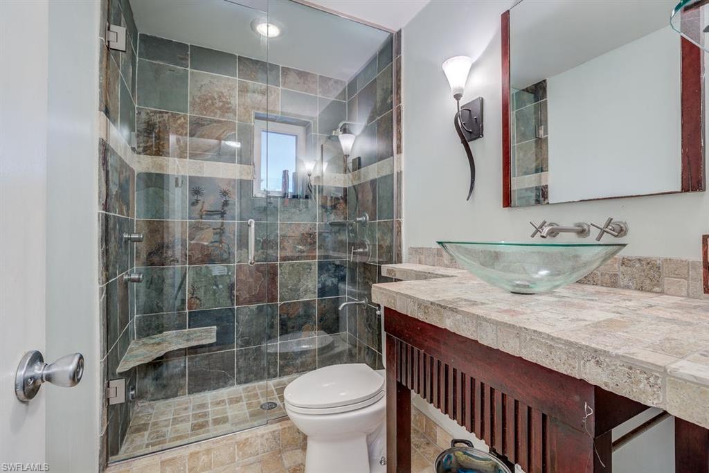 9144 7th Street North Naples, FL 34108 - Photo 3 of 20 a bathroom with a granite countertop sink a toilet and shower