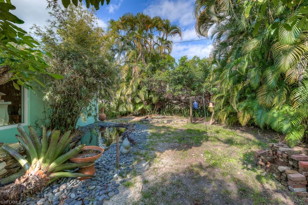 9144 7th Street North Naples, FL 34108 - Photo 4 of 20 a view of a yard with plants and large trees