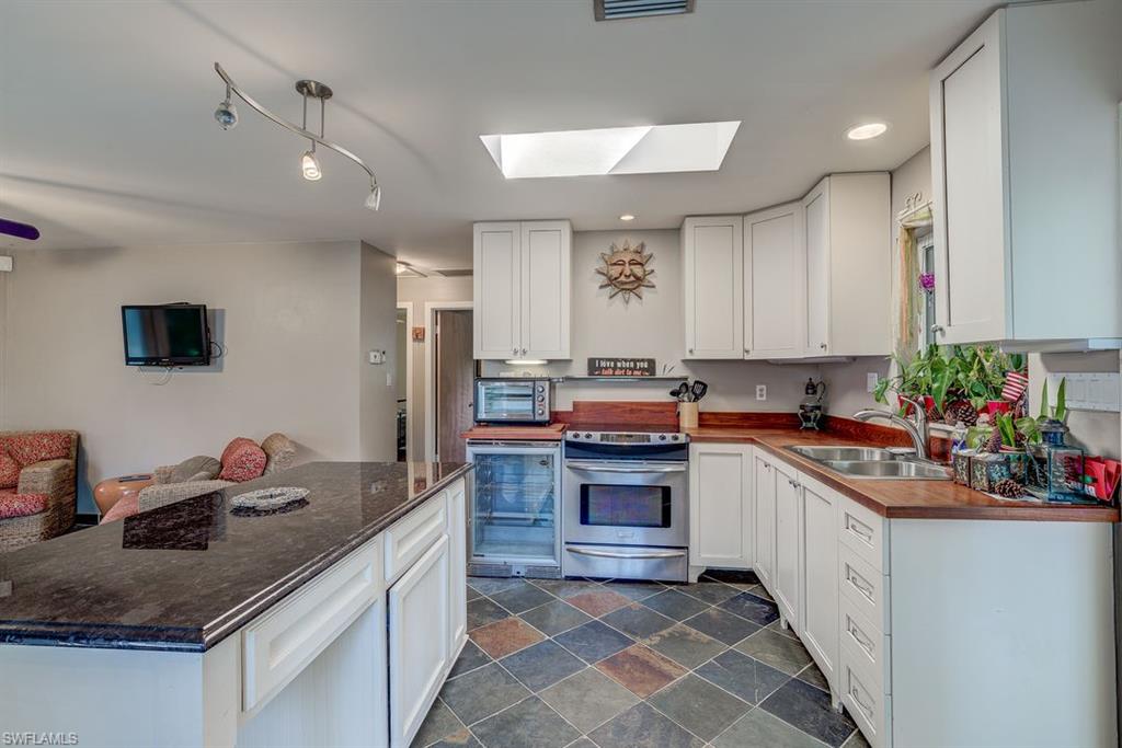 9144 7th Street North Naples, FL 34108 - Photo 5 of 20 a kitchen with stainless steel appliances granite countertop a sink stove and cabinets