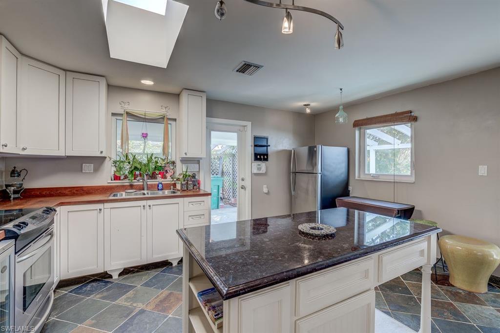 9144 7th Street North Naples, FL 34108 - Photo 6 of 20 a kitchen with stainless steel appliances granite countertop a sink refrigerator and cabinets