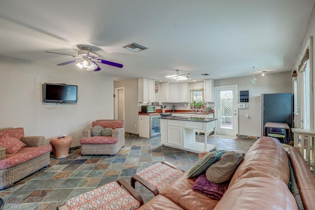 9144 7th Street North Naples, FL 34108 - Photo 7 of 20 a living room with furniture kitchen view and a flat screen tv