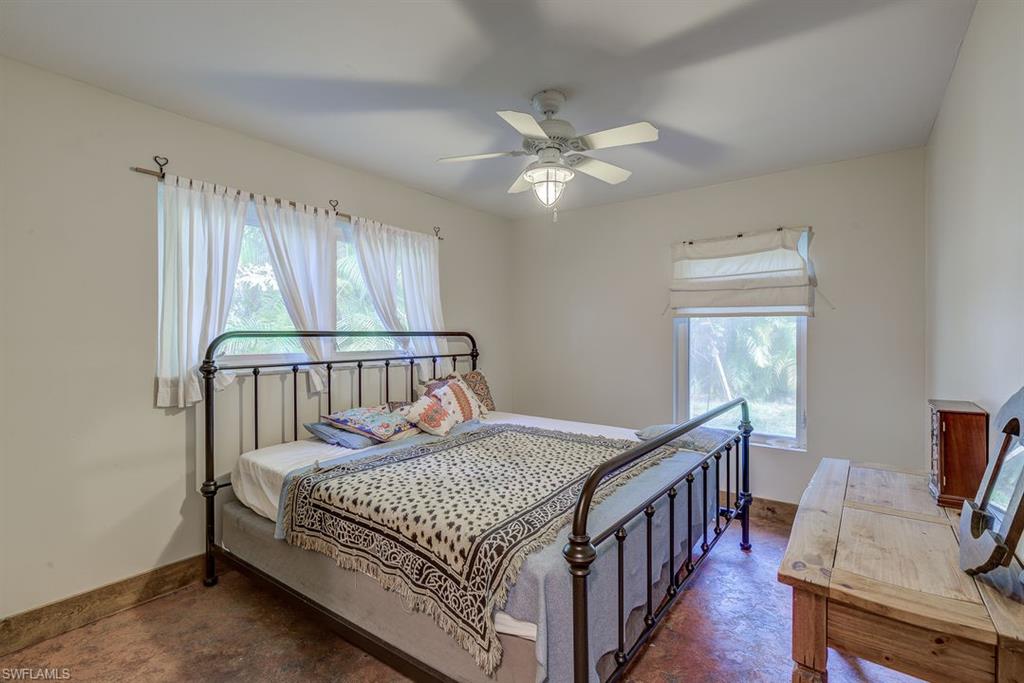 9144 7th Street North Naples, FL 34108 - Photo 8 of 20 a bedroom with a bed and a chandelier