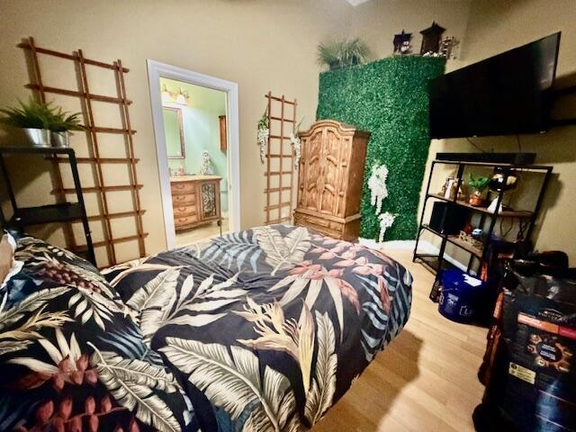 11666 Southwest Meadowlark Circle Stuart, FL 34997 - Photo 12 of 40 a bedroom with a bed a flat screen tv and a large window