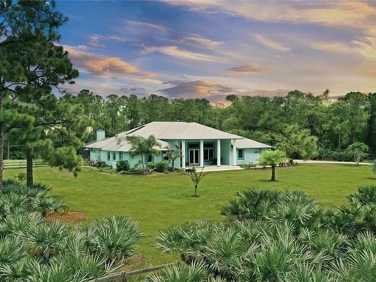 11666 Southwest Meadowlark Circle Stuart, FL 34997 - Photo 2 of 40 a view of an outdoor space with a garden and trees