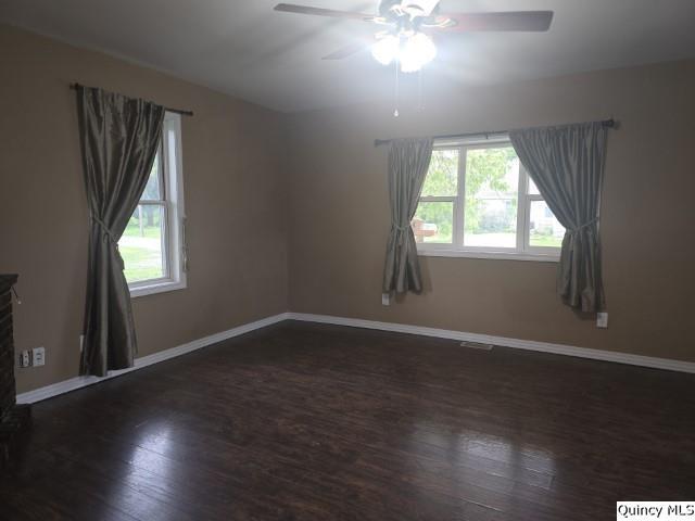 303 North Washington Street Carthage, IL 62321 - Photo 8 of 25 an empty room with wooden floor and windows