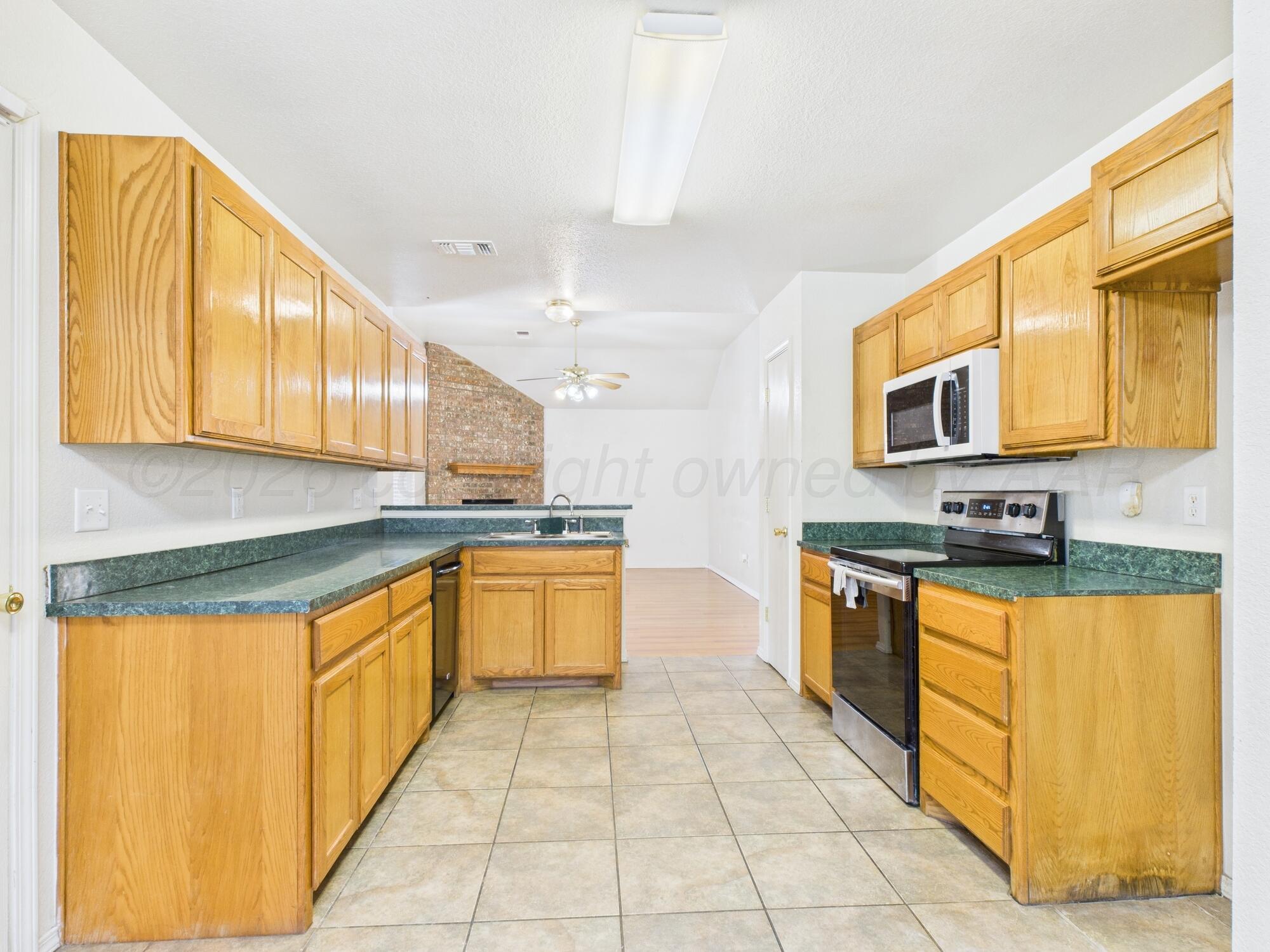 1111 Pikes Peak Drive Amarillo, TX 79110 - Photo 3 of 25 a large kitchen with stainless steel appliances granite countertop a stove a sink and a microwave