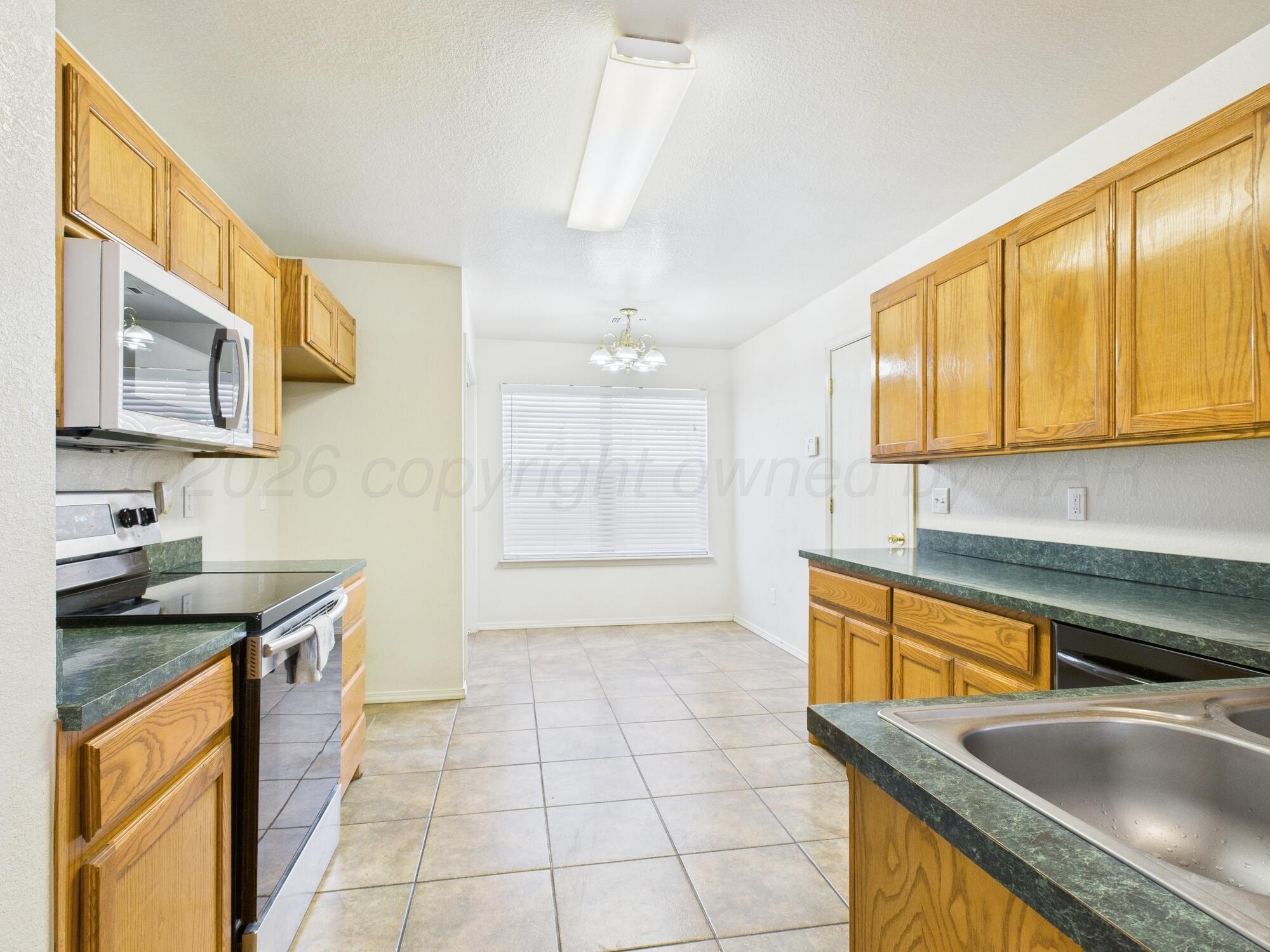 1111 Pikes Peak Drive Amarillo, TX 79110 - Photo 7 of 25 a kitchen with a sink stove and cabinets