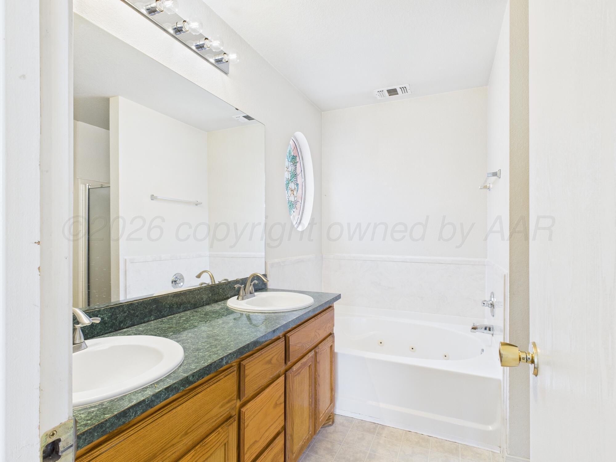 1111 Pikes Peak Drive Amarillo, TX 79110 - Photo 10 of 25 a bathroom with a granite countertop tub sink and mirror