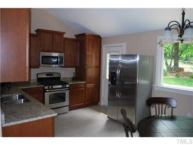 210 Quail Drive Raleigh, NC 27604 - Photo 9 of 17 a kitchen with a refrigerator and a stove top oven