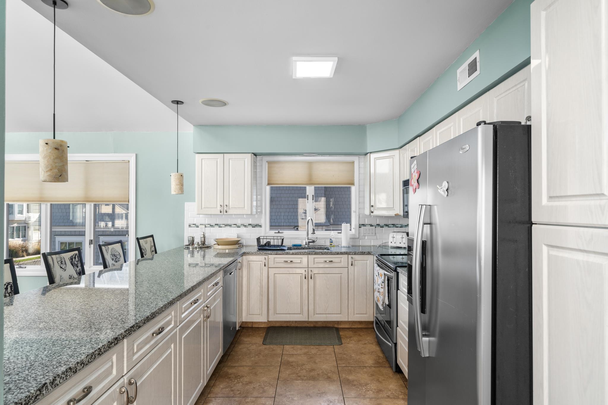 58 East 15th Street Avalon, NJ 08202 - Photo 12 of 24 a kitchen with stainless steel appliances granite countertop a sink a stove and refrigerator