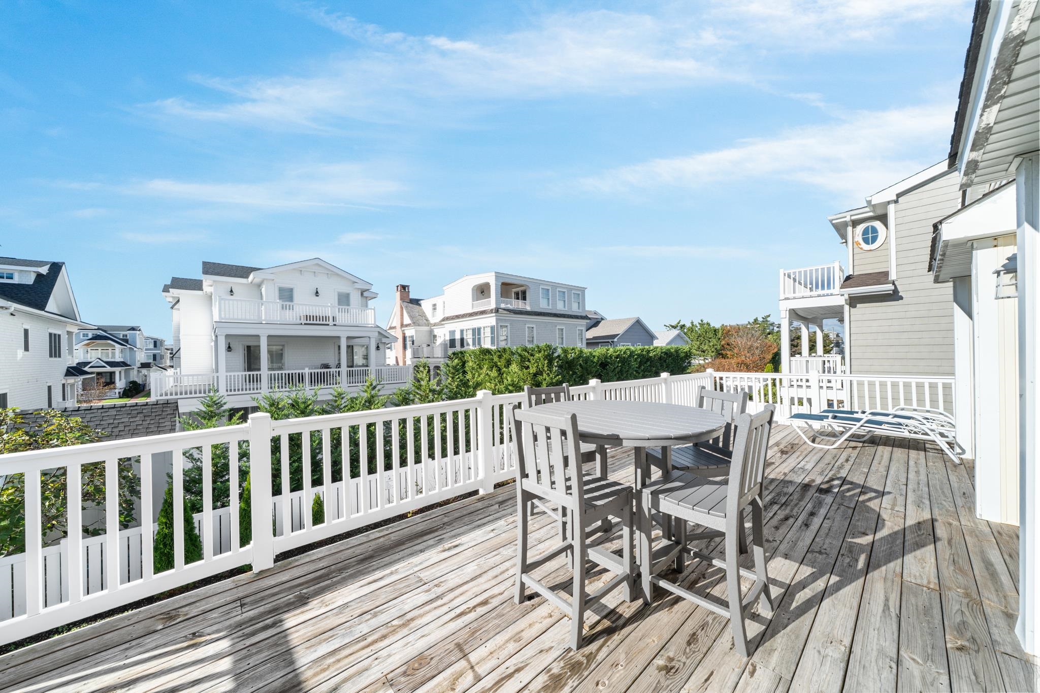 58 East 15th Street Avalon, NJ 08202 - Photo 24 of 24 a view of a roof deck with table and chairs with wooden floor and fence