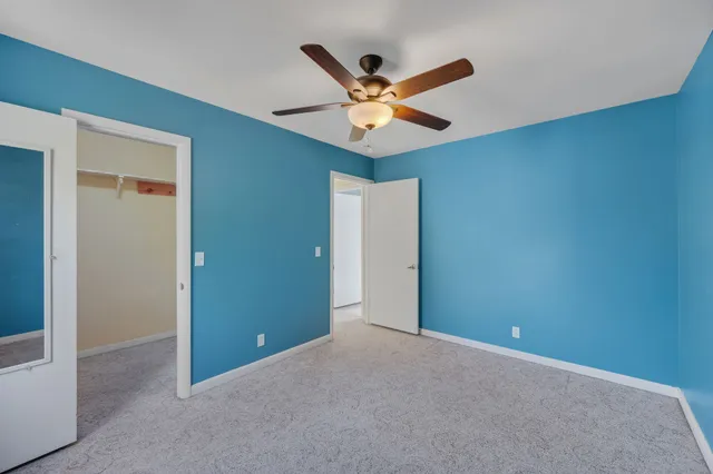 an empty room with a ceiling fan and a window