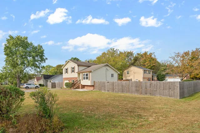 a view of a large house with a big yard and large tree
