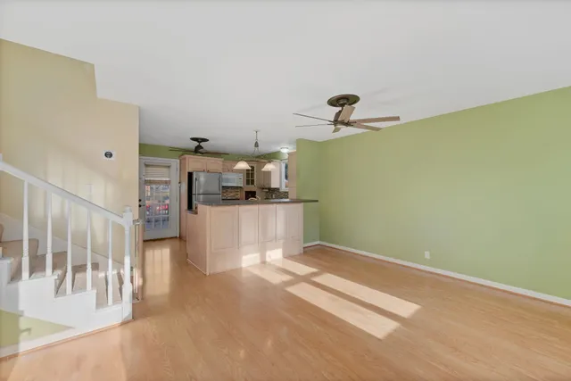 a view of a livingroom with wooden floor and a ceiling fan