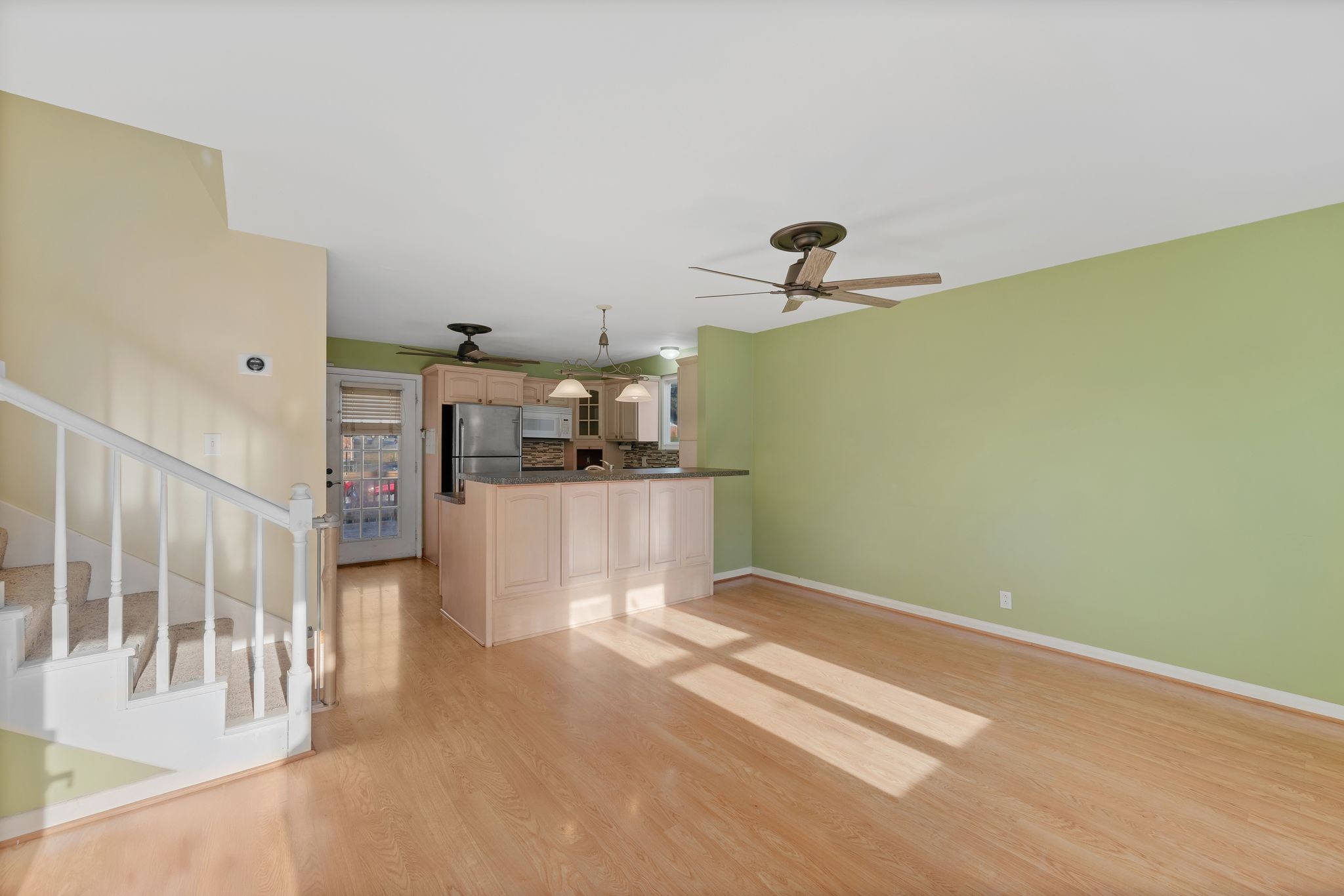 135 Grenadier Drive Franklin, TN 37064 - Photo 5 of 27 a view of a livingroom with wooden floor and a ceiling fan