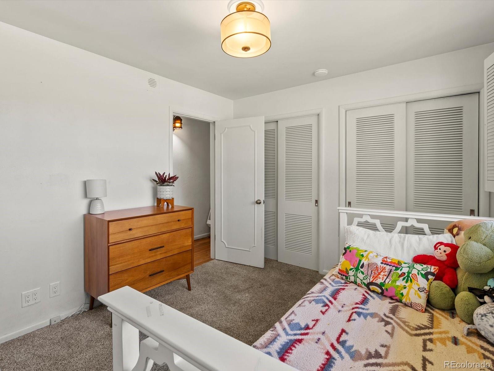10400 West 35th Place Wheat Ridge, CO 80033 - Photo 11 of 44 a bedroom with a bed and a chandelier