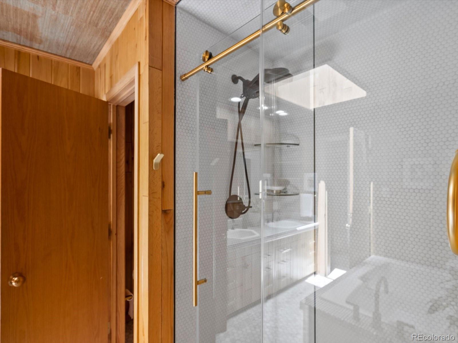 10400 West 35th Place Wheat Ridge, CO 80033 - Photo 30 of 44 a bathroom with a glass shower door and a sink