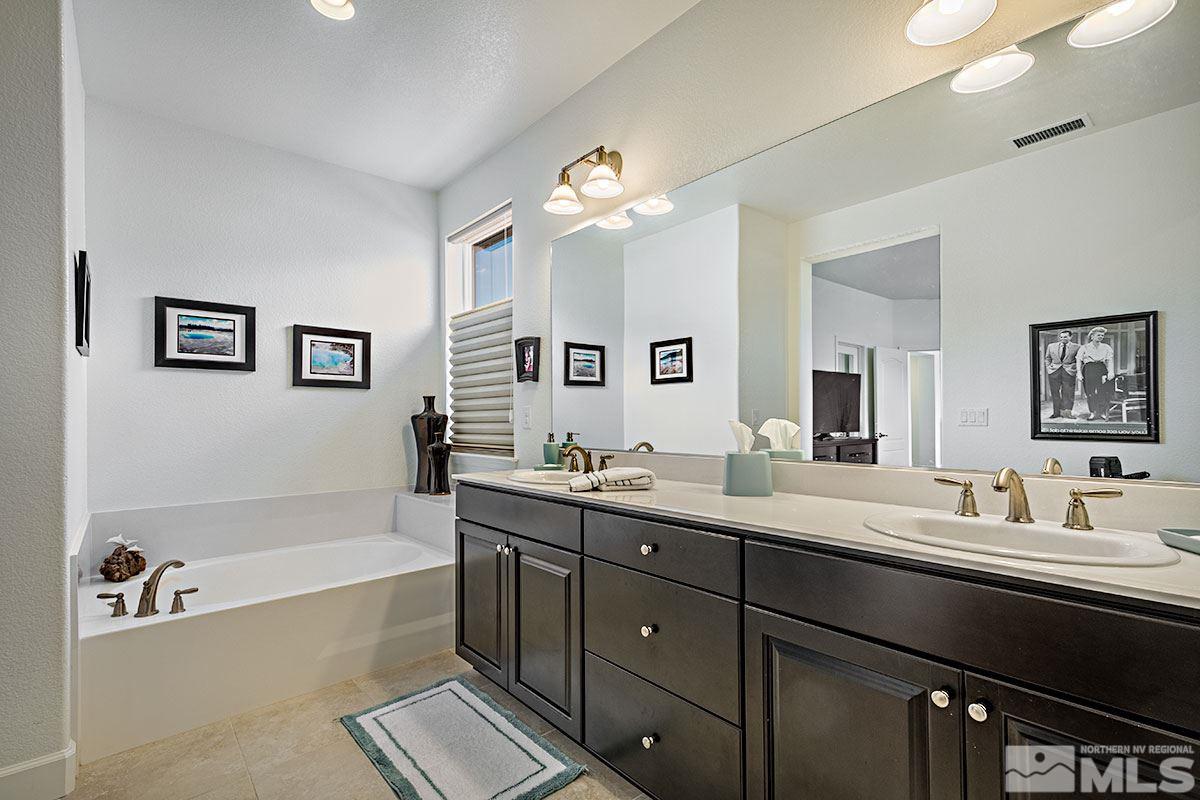 3020 Bull Rider Drive Reno, NV 89521 - Photo 14 of 25 a bathroom with a tub a sink double vanity and a mirror