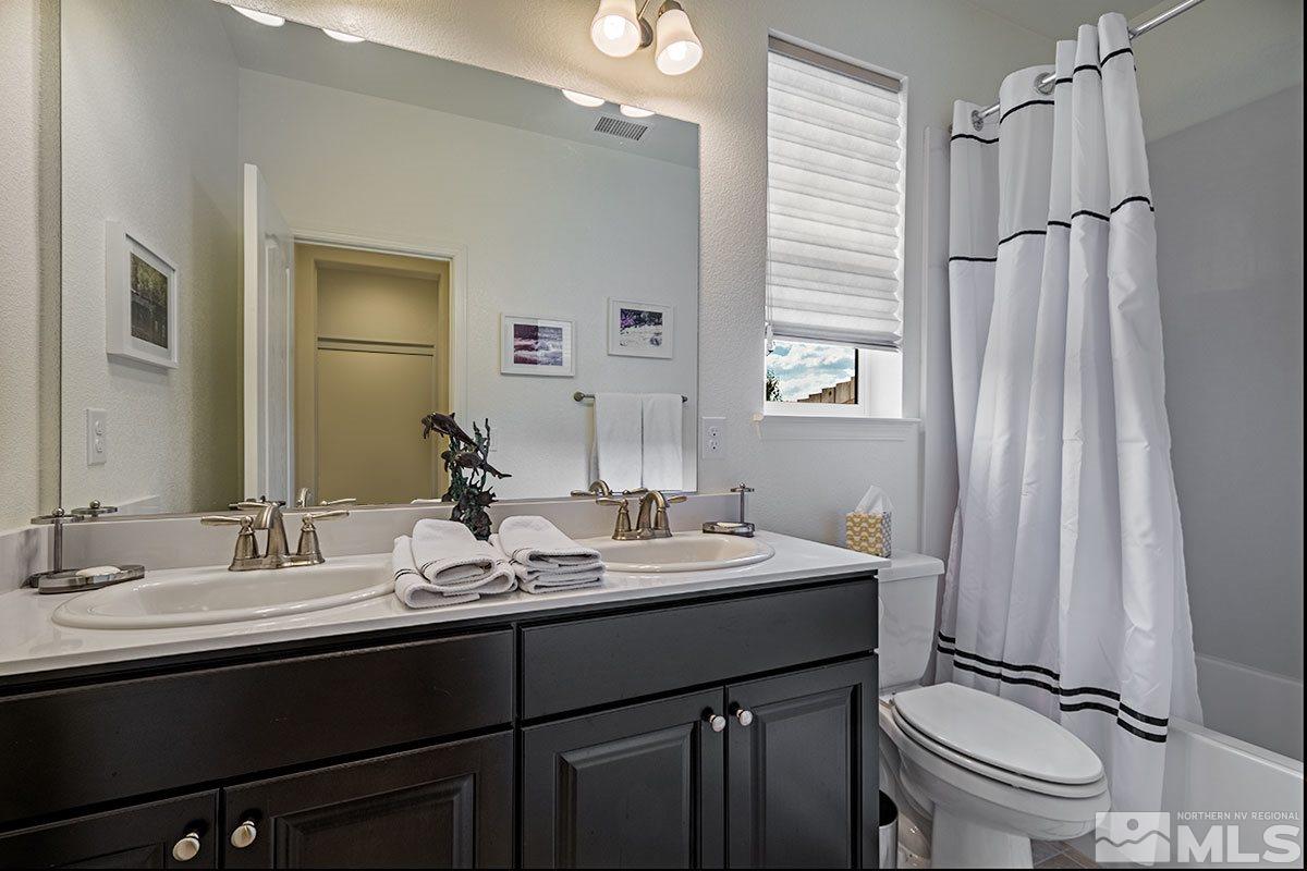 3020 Bull Rider Drive Reno, NV 89521 - Photo 18 of 25 a bathroom with a double vanity sink toilet and a mirror