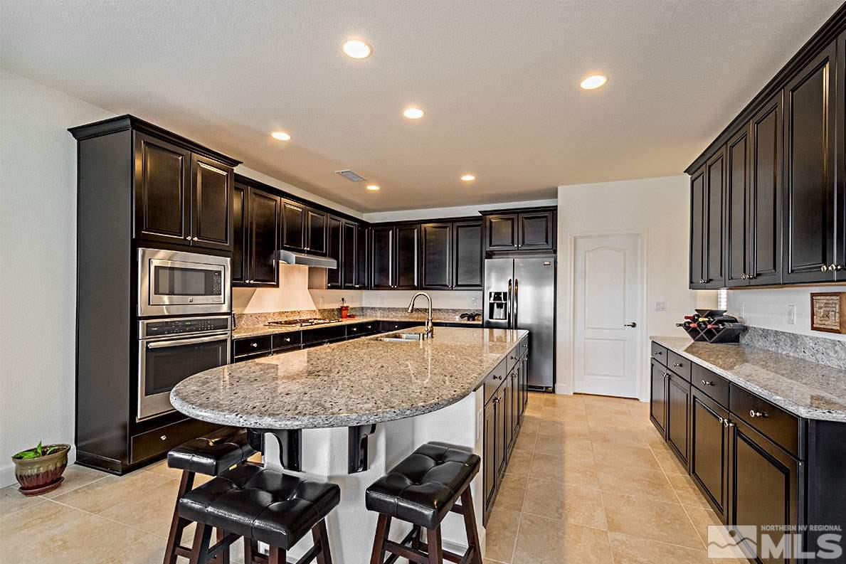 3020 Bull Rider Drive Reno, NV 89521 - Photo 6 of 25 a kitchen with stainless steel appliances granite countertop a stove a sink a microwave and a refrigerator