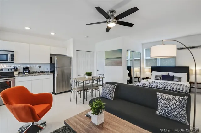 a living room with furniture and a refrigerator