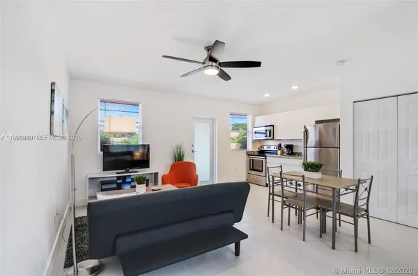 a living room with furniture a flat screen tv and a table