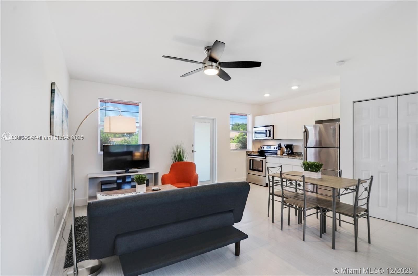 2601 Northwest 1st Avenue, Unit 6 Miami, FL 33127 - Photo 5 of 11 a living room with furniture a fireplace and a flat screen tv
