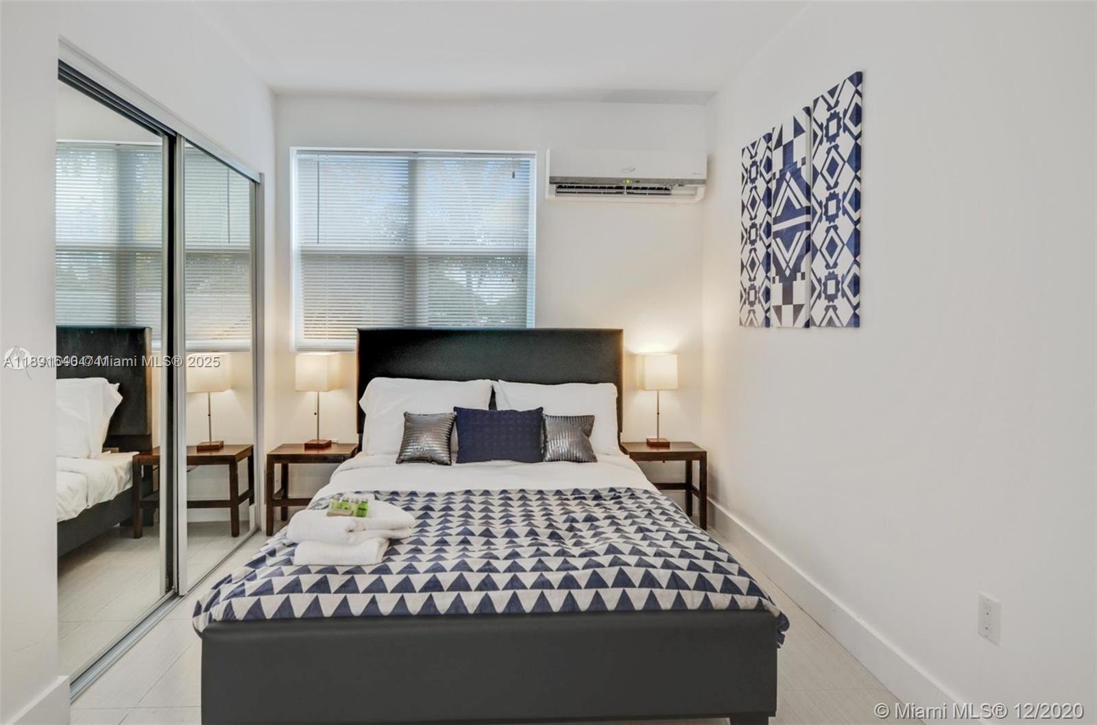 2601 Northwest 1st Avenue, Unit 6 Miami, FL 33127 - Photo 6 of 11 a bedroom with a large bed and wooden floor