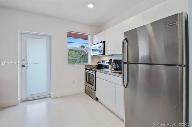 a kitchen with stainless steel appliances granite countertop a refrigerator and a sink