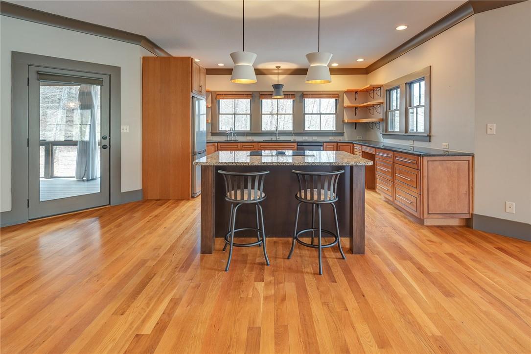 23 Ruffed Grouse Drive Weaverville, NC 28787 - Photo 11 of 48 a open kitchen with stainless steel appliances granite countertop a stove top oven a dining table and chairs with wooden floor
