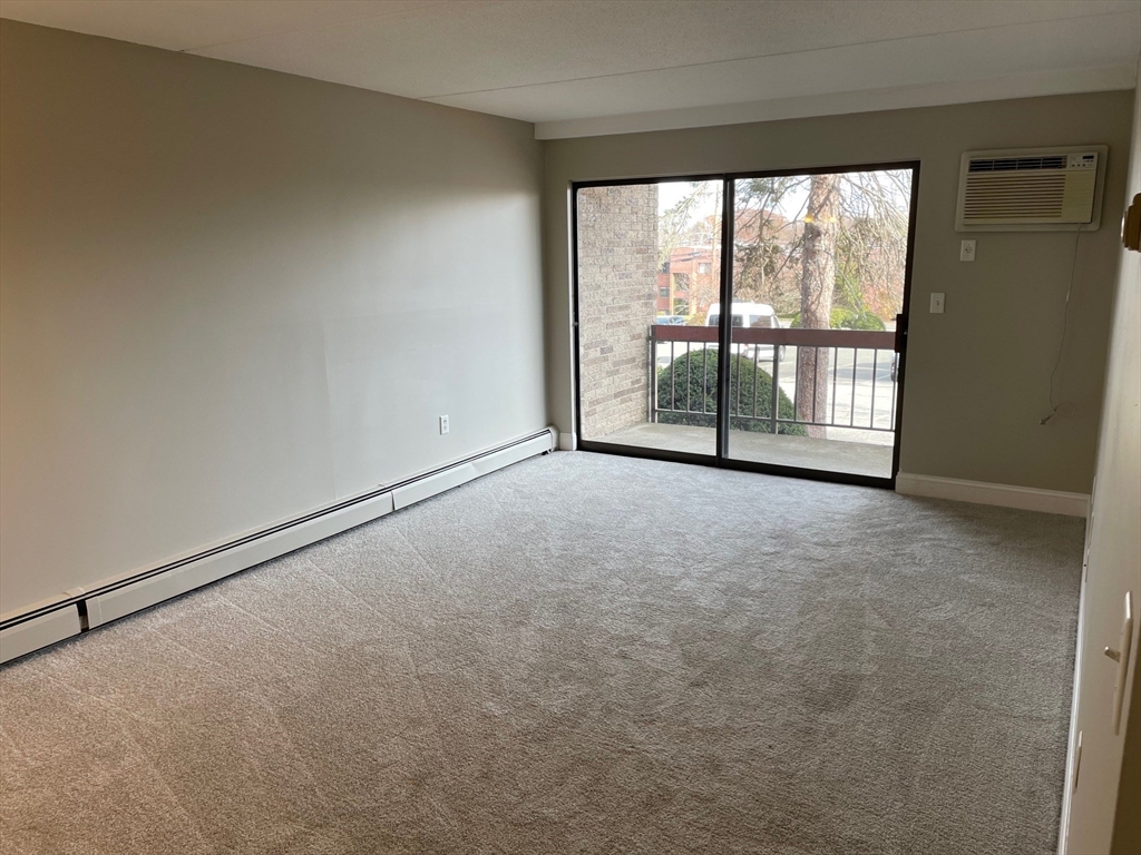 59 Cambridge Road, Unit 108 Woburn, MA 01801 - Photo 2 of 11 an empty room with windows