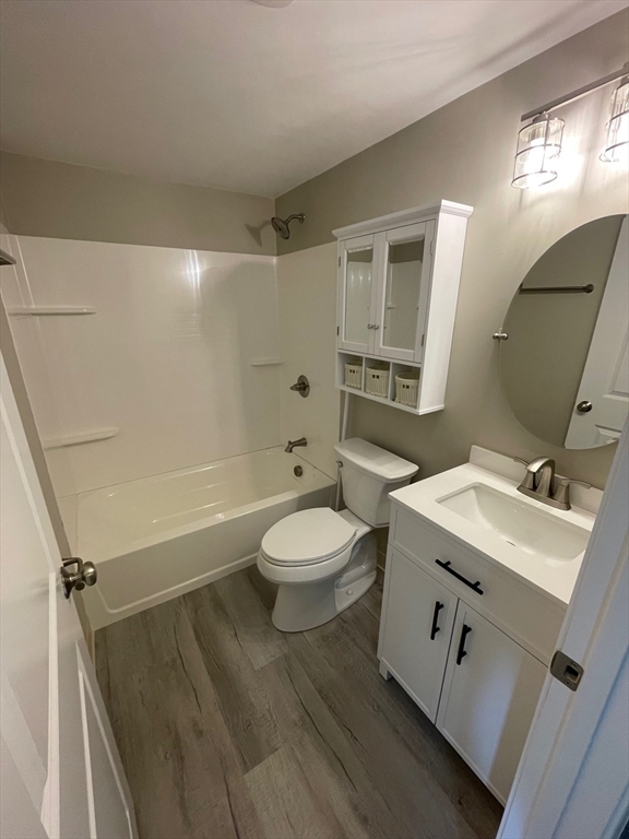 59 Cambridge Road, Unit 108 Woburn, MA 01801 - Photo 7 of 11 a bathroom with a sink a toilet a mirror and shower