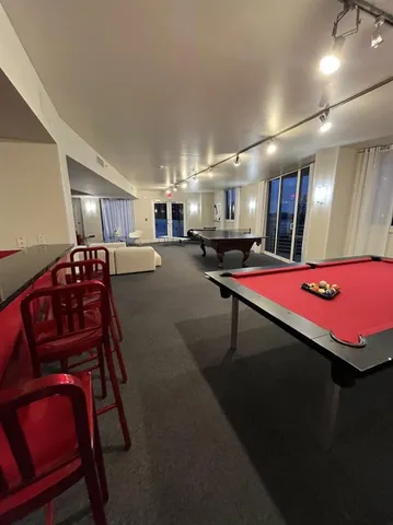 a view of a building with a sink and pool table and chairs
