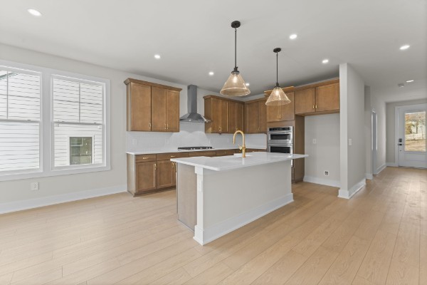 826 Silva Loop Mount Juliet, TN 37122 - Photo 12 of 24 a large kitchen with kitchen island granite countertop a stove a sink a refrigerator and white cabinets with wooden floor