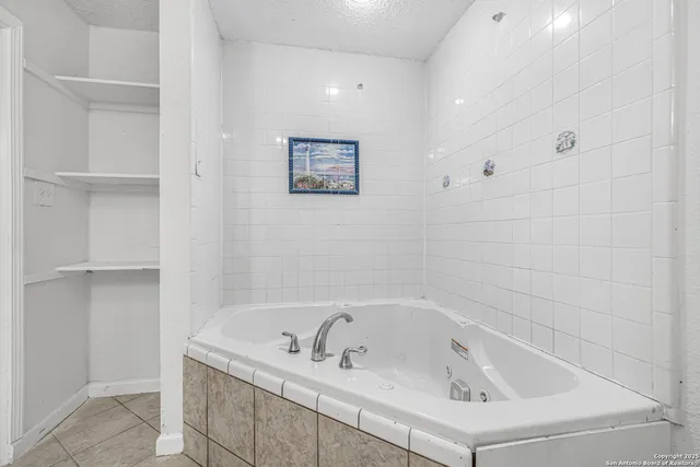 a white bath tub sitting next to a white sink and vanity