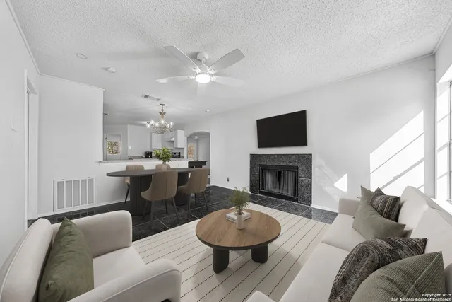 a living room with furniture a fireplace and a large window